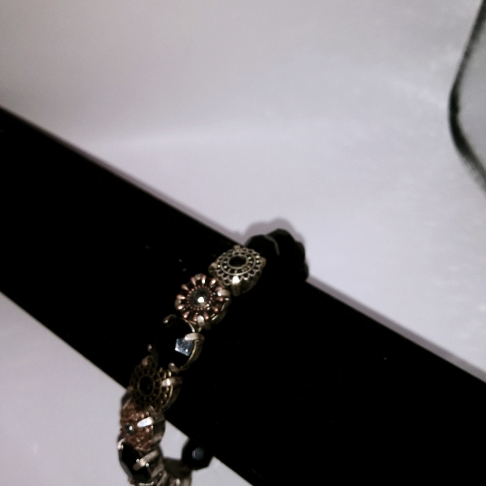 Black bead bracelet with silvertone settings with colored stone settings.